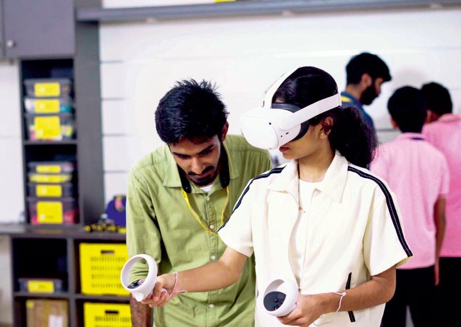 A student tries a virtual reality headset with a mentor